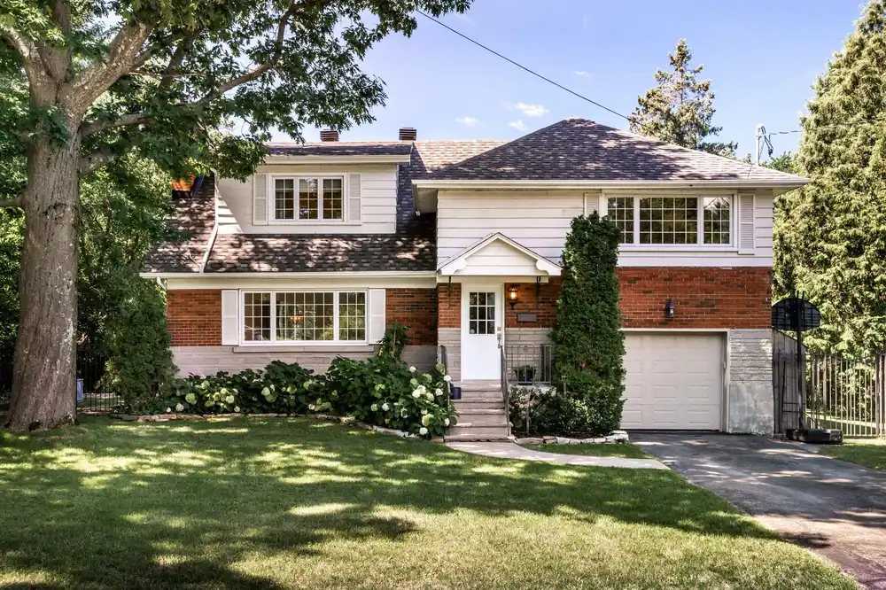 Split-level home from the 1970s era with mature landscaping