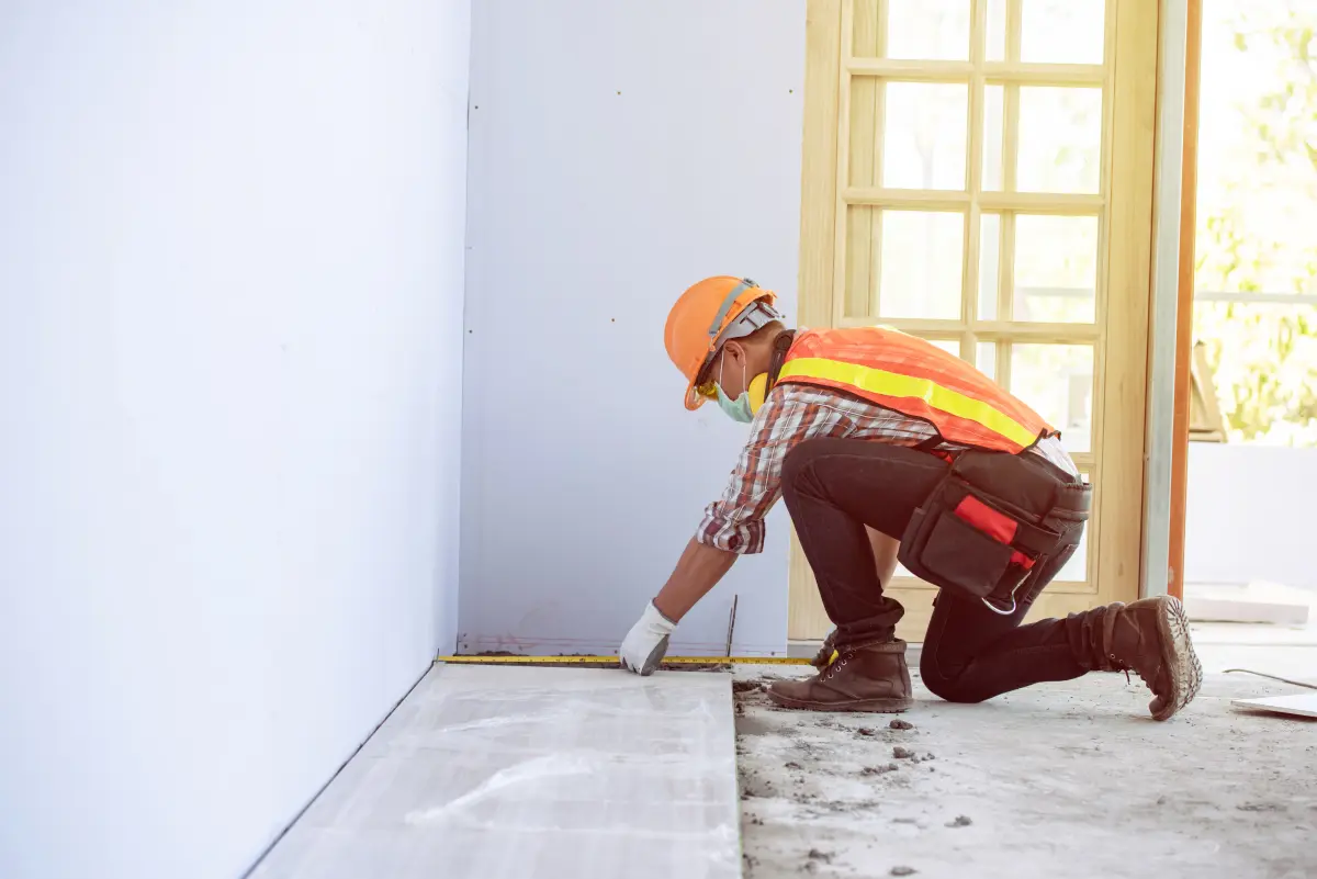 Worker measuring flooring during an interior remodel