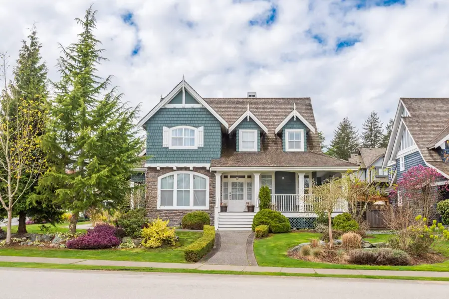 Craftsman style house with covered porch and evergreen trees
