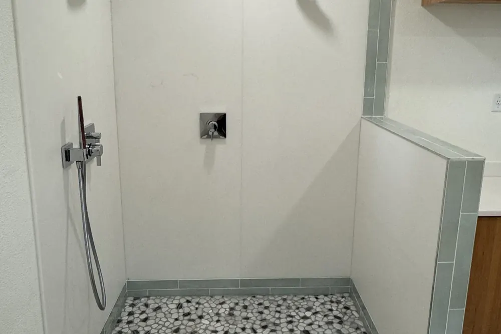 Tiled walk-in shower with glass enclosure after a bathroom remodel